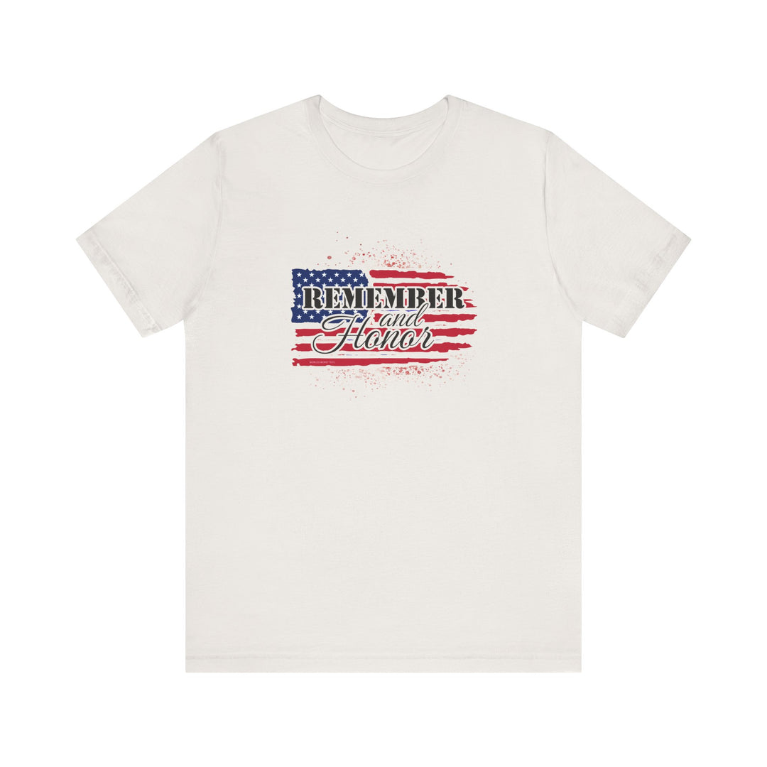A white t-shirt featuring a flag and text design, the Remember and Honor Tee. Unisex jersey tee with ribbed knit collar, taping on shoulders, and tear-away label. Made of 100% Airlume combed cotton.