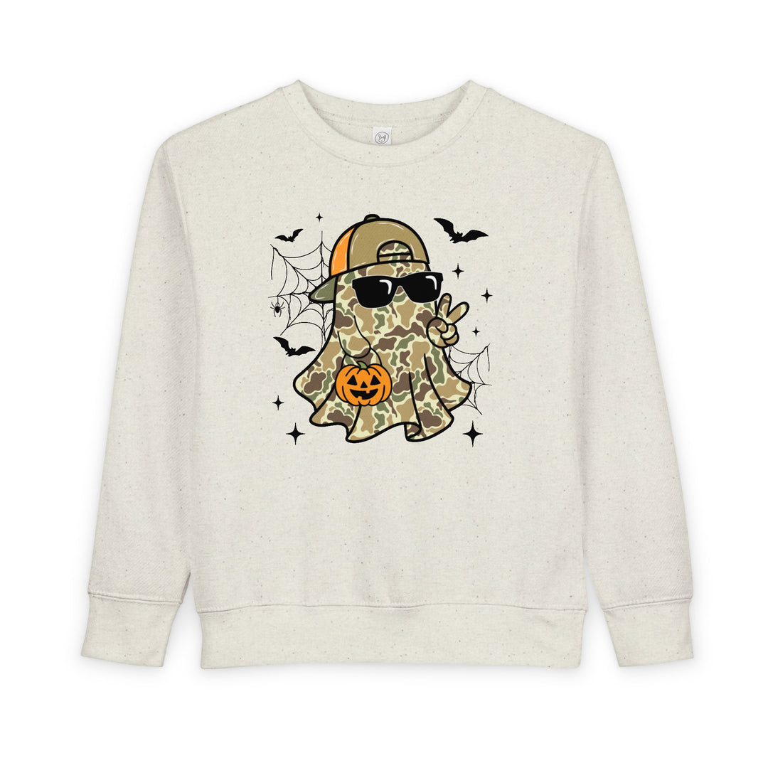 Candy Ghost Toddler Crew sweatshirt showcases a playful ghost in camo with sunglasses, holding a jack-o’-lantern, surrounded by bats and webs. Cozy, durable design for toddlers.