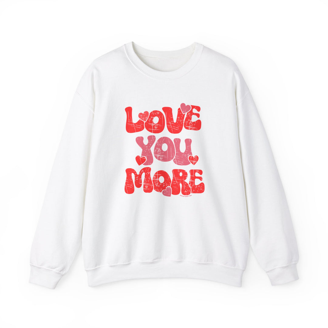 A unisex heavy blend crewneck sweatshirt, Love You More Crew, in white with red text. Comfortable, loose fit, ribbed knit collar, no itchy side seams. Made of 50% cotton, 50% polyester.