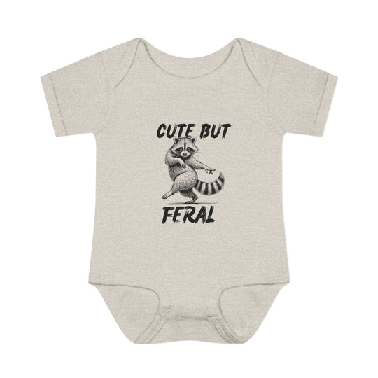 Light-heathered baby onesie with hand-drawn raccoon and CUTE BUT FERAL text, emphasizing playful design and soft, comfortable fit for infants.