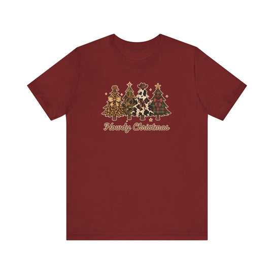 Howdy Christmas Tee with four Western-themed Christmas trees featuring prints like leopard, camouflage, cowhide, and plaid, adorned with cowboy hats and bows.