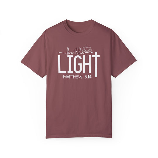 A maroon Be the Light Tee, garment-dyed 100% ring-spun cotton, medium weight, relaxed fit, durable double-needle stitching, seamless design for tubular shape.