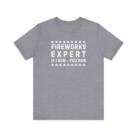 A grey Firework Expert Tee, a classic unisex jersey shirt with white text. Made of 100% Airlume combed cotton, featuring ribbed knit collars and taping on shoulders for a better fit. Sizes XS to 3XL.