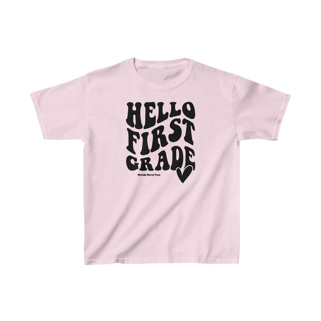 A pink kids 1st Grade Tee with black text, made of 100% cotton for solid colors, featuring twill tape shoulders and ribbed knitting collar for durability. Classic fit, tear-away label, runs true to size.