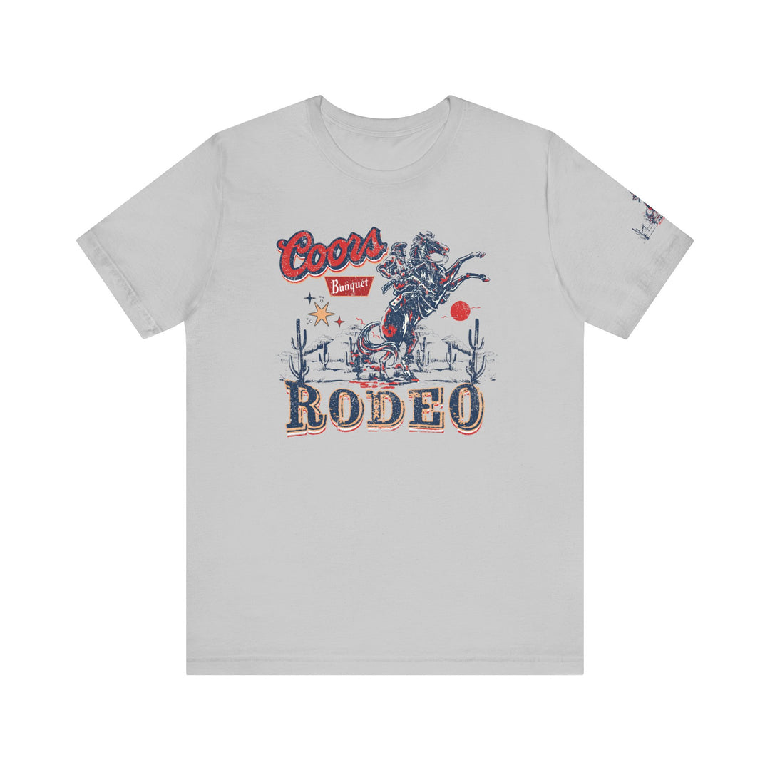 A classic Coors Rodeo Tee featuring a graphic cowboy design on a white shirt. Unisex jersey tee with ribbed knit collars, taping on shoulders, and 100% Airlume combed cotton. Retail fit, tear away label, and true-to-size fit.