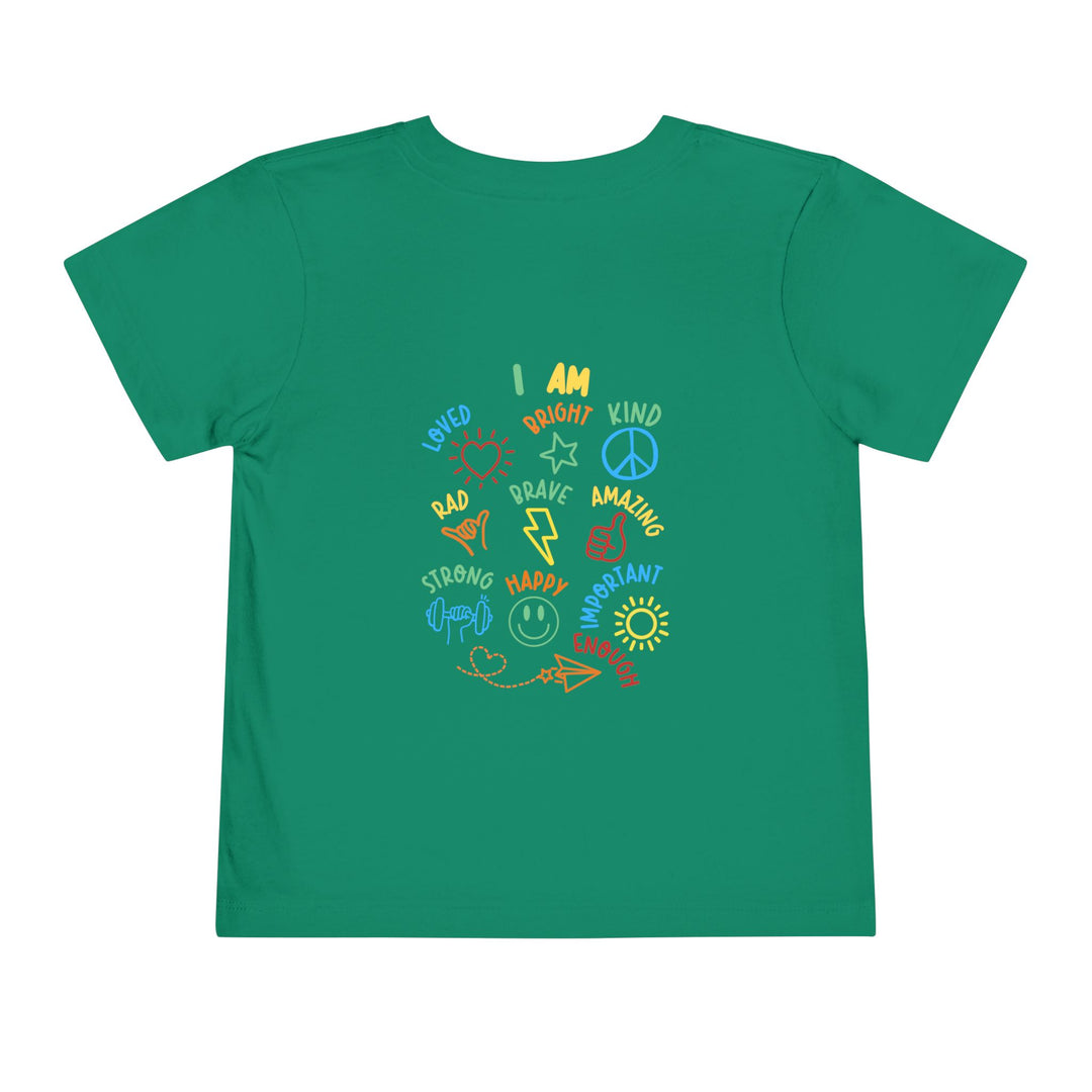 Child's green I AM Toddler Tee featuring positive doodles like hearts and stars, promoting affirmations such as Loved and Brave, on soft cotton fabric.