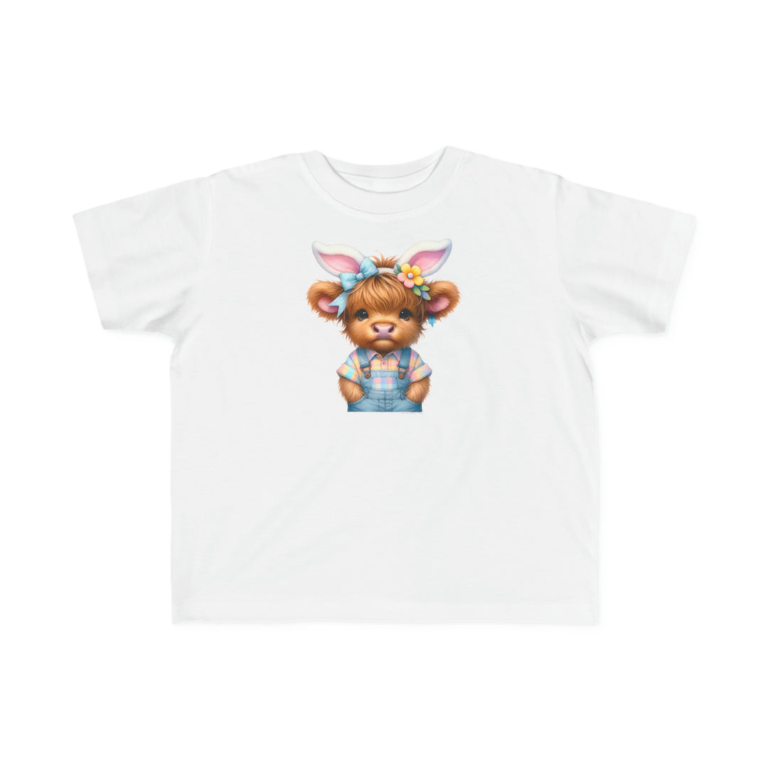 Easter Cow Toddler Tee: A white t-shirt featuring a cartoon cow with bunny ears, perfect for sensitive skin. Made of 100% combed ringspun cotton, light fabric, classic fit, and tear-away label.
