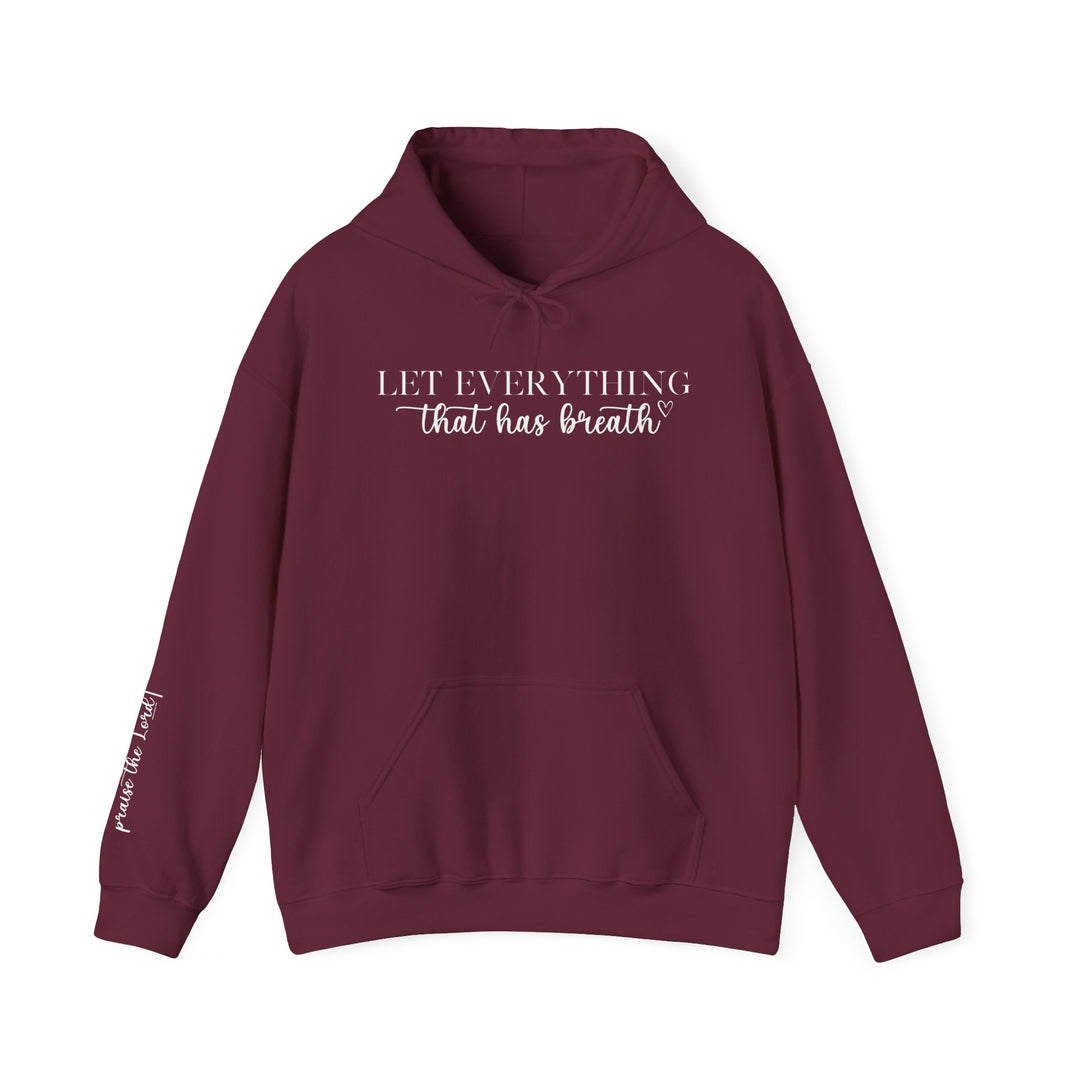 A maroon hooded sweatshirt with white text, featuring a kangaroo pocket and drawstring hood. Unisex heavy blend for warmth and comfort, ideal for cold days. Let Everything That Has Breath Praise the Lord Hoodie by Worlds Worst Tees.