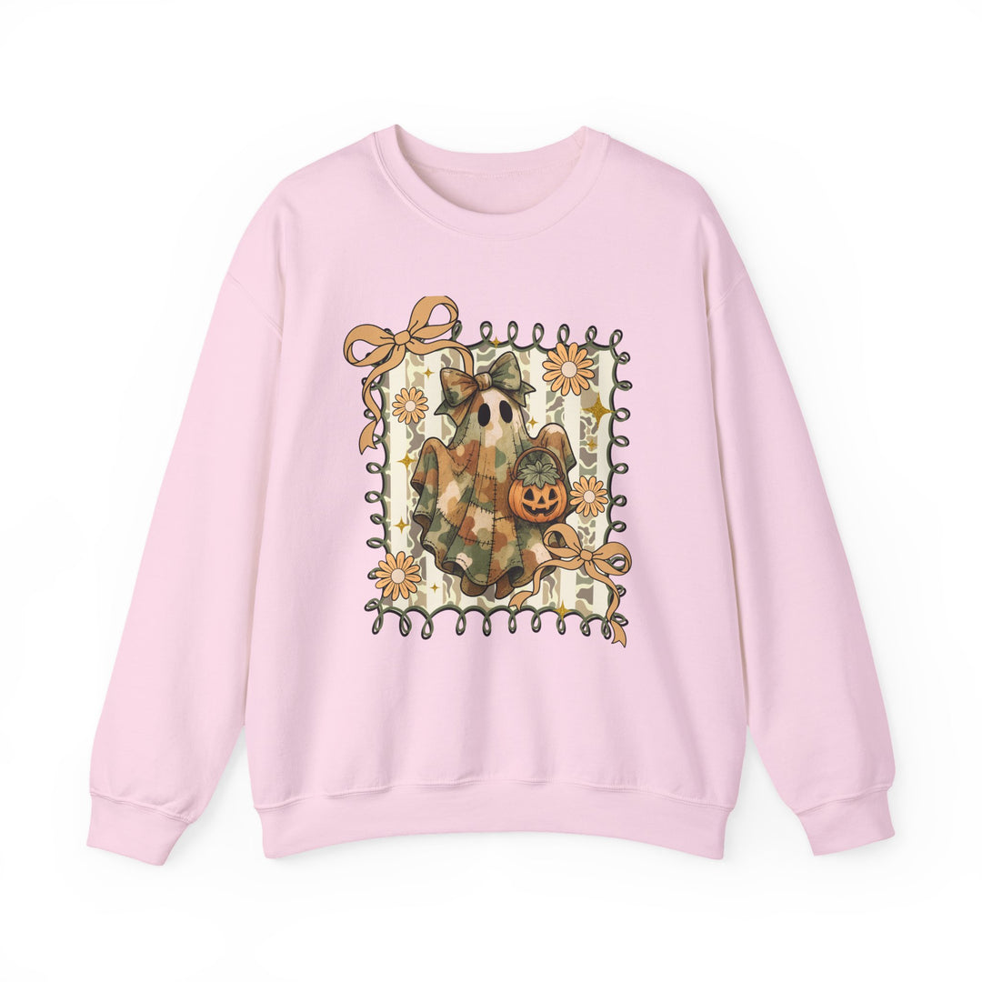 Pale-pink crewneck sweatshirt featuring a whimsical Halloween motif: a camo-toned ghost with a bow and jack-o'-lantern bucket, surrounded by playful ribbons and daisies.