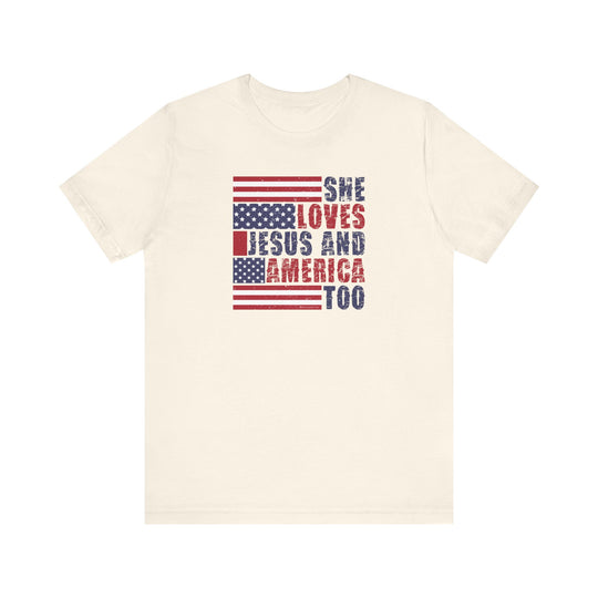 A classic She Loves Jesus and America Tee, a white t-shirt with red and blue text. Unisex jersey shirt with ribbed knit collars, taping on shoulders, and side seams for shape retention. Made of 100% Airlume combed cotton.