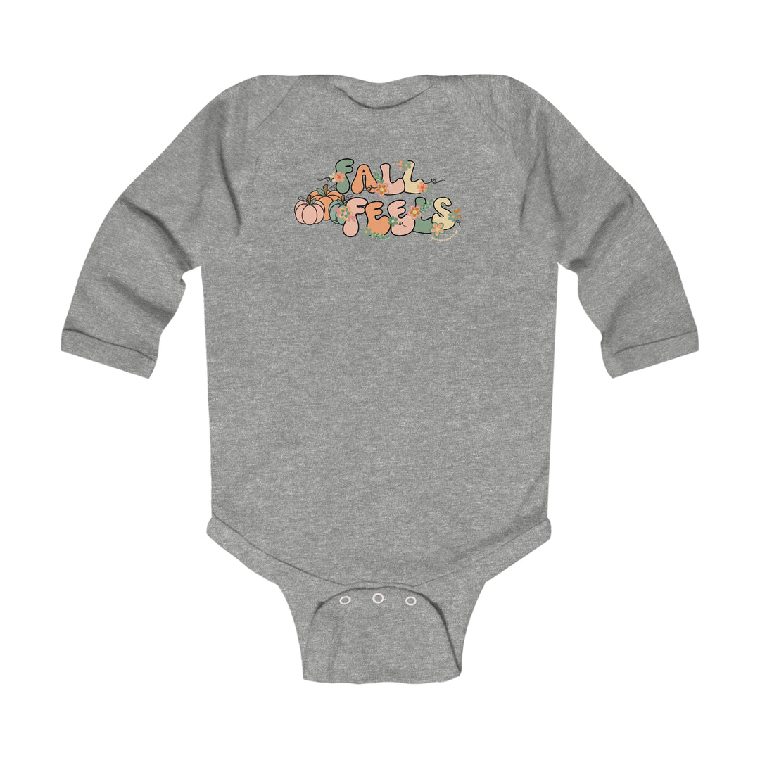 A grey baby bodysuit with a logo, featuring a Fall Feels Long Sleeved Onesie design for infants. Made of soft cotton, with plastic snaps for easy changing. From Worlds Worst Tees.