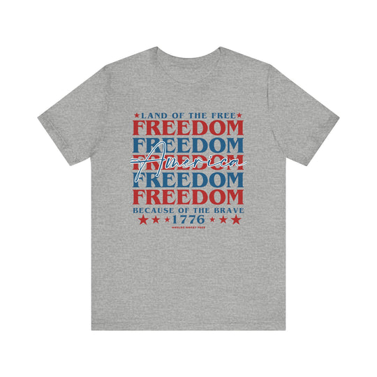 American Freedom Tee: Unisex jersey t-shirt with red and blue text. Airlume combed cotton, ribbed knit collar, taping on shoulders, and dual side seams for durability. Retail fit, light fabric. Sizes XS-3XL.
