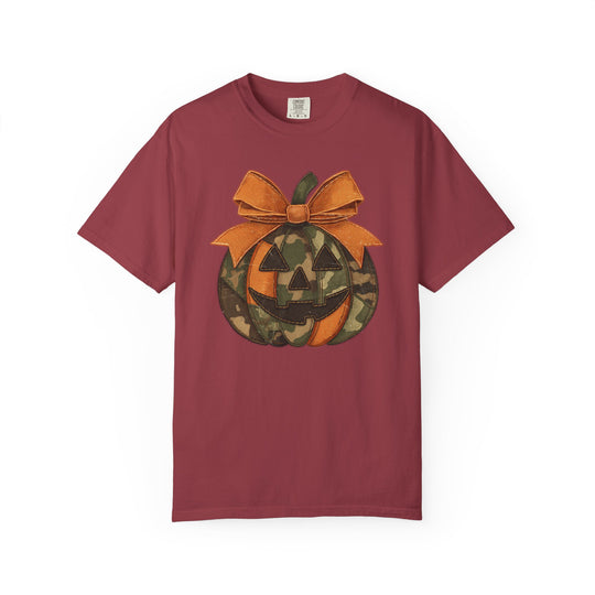 Jackie O Tee features a stylized jack-o’-lantern with camouflage and orange design on a maroon crew-neck shirt, offering durable comfort and a relaxed fit.