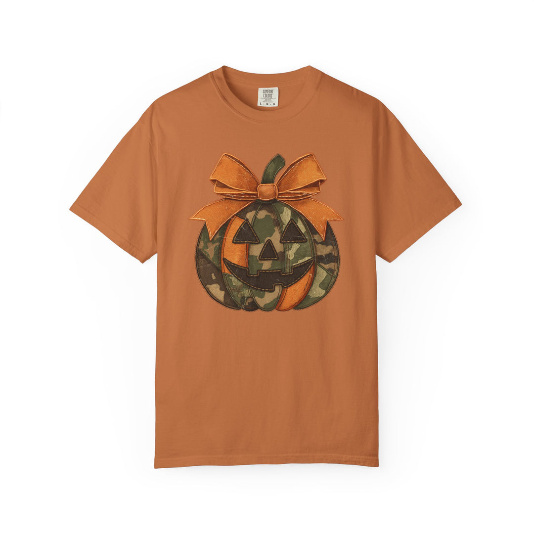 Jackie O Tee: Halloween-themed orange cotton tee with jack-o’-lantern design in camo and bright orange panels, topped with a stitched orange bow.