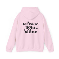 A pink hoodie with black text, featuring a star design, from Worlds Worst Tees. Unisex heavy blend for comfort, kangaroo pocket, and matching drawstring. Let Your Light Shine Hoodie.