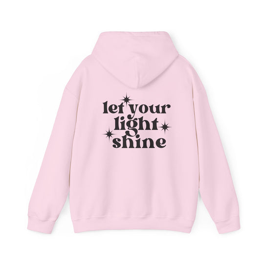 A pink hoodie with black text, featuring a star design, from Worlds Worst Tees. Unisex heavy blend for comfort, kangaroo pocket, and matching drawstring. Let Your Light Shine Hoodie.