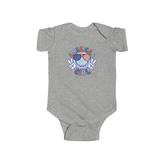 An American Girl onesie featuring a cartoon character and peace sign design. Made of 100% cotton for durability and softness. Plastic snaps for easy changing access. From Worlds Worst Tees.