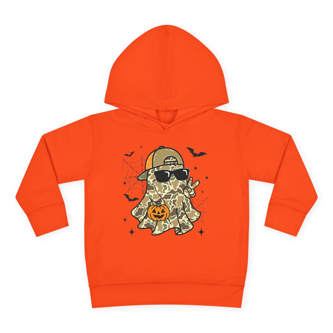 Candy Ghost Toddler Hoodie features a playful camouflage ghost with a cap, sunglasses, peace sign, and jack-o’-lantern, surrounded by bats and webs.