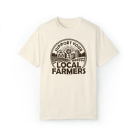 A white t-shirt with a logo for a local farmers market, featuring a graphic design. Unisex garment-dyed sweatshirt with a relaxed fit, 80% ring-spun cotton, and 20% polyester blend. From Worlds Worst Tees.