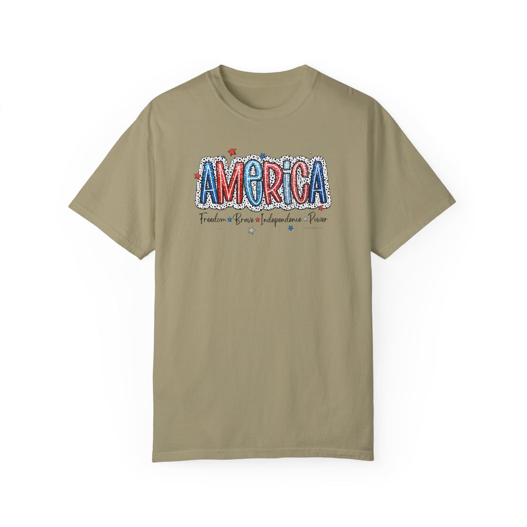 A tan America Tee, crafted from 100% ring-spun cotton. Garment-dyed for extra coziness, with double-needle stitching for durability and a relaxed fit for daily wear.
