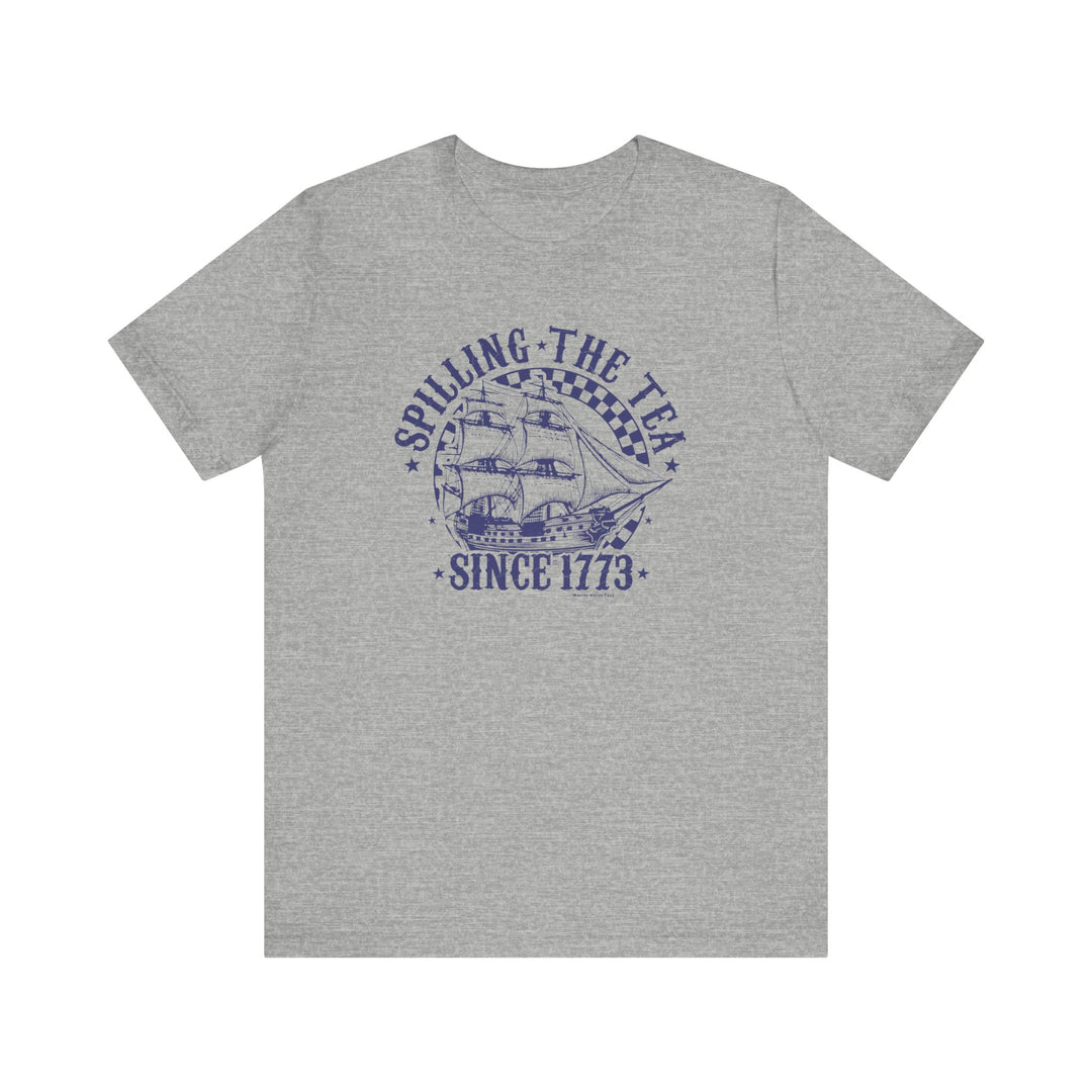 Spilling the Tea Since 1773 Tee: Grey t-shirt with sailboat graphic and blue text. Unisex jersey tee made of 100% cotton, retail fit, tear away label, and ribbed knit collars for a comfy, stylish look.