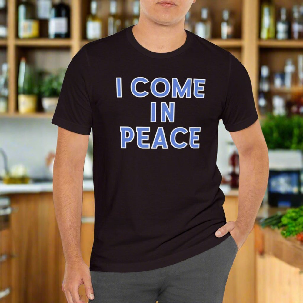 A man in a black I Come in Peace tee, showcasing a quality cotton shirt with ribbed knit collar and taping on shoulders. Unisex fit, light fabric. From Worlds Worst Tees.