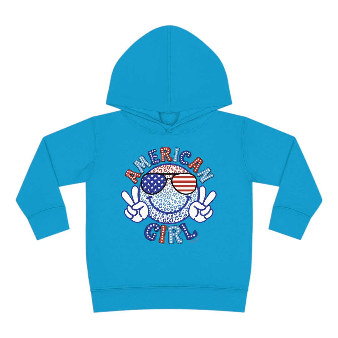 American Girl Toddler Hoodie featuring a smiley face with sunglasses and a peace sign. Jersey-lined hood, cover-stitched details, and side seam pockets for durability and coziness. Designed in 60% cotton, 40% polyester blend.