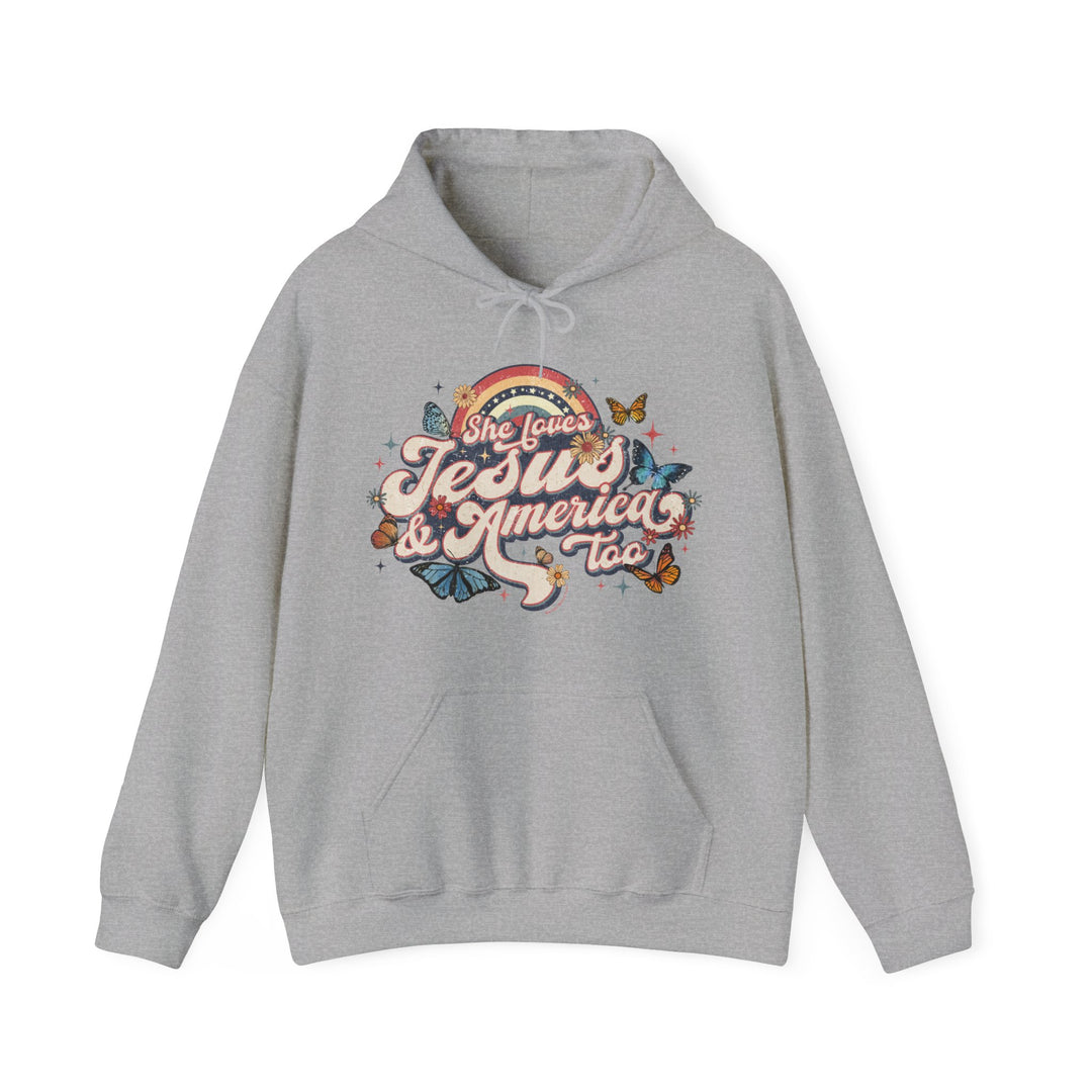 A grey She Loves Jesus and America hoodie with a graphic design of butterflies and flowers. Unisex heavy blend, cotton-polyester fabric, kangaroo pocket, and drawstring hood. Classic fit, tear-away label, true to size.