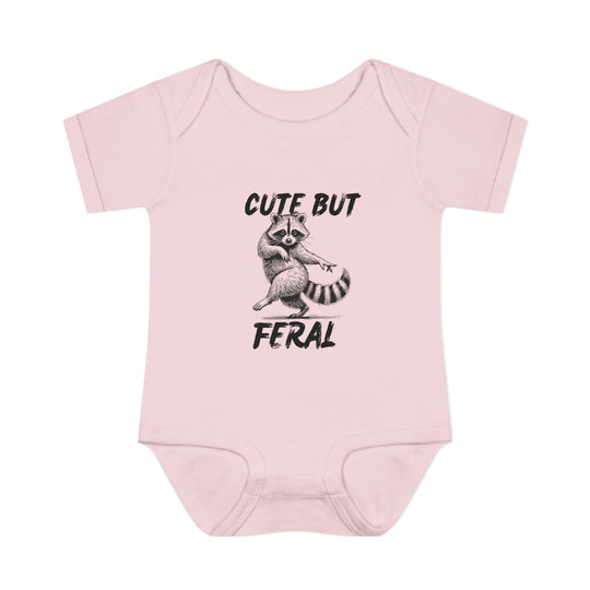Light-pink Cute But Feral onesie featuring a sketch of a pointing raccoon, designed for comfort with soft, 100% combed ringspun cotton and convenient lap shoulders.
