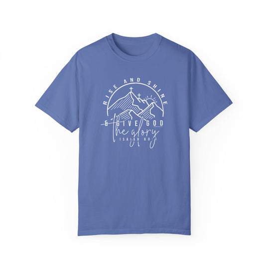 A relaxed fit Rise and Shine Tee, a blue shirt with white text, features a cross and mountains logo. Made of 100% ring-spun cotton for durability and comfort.