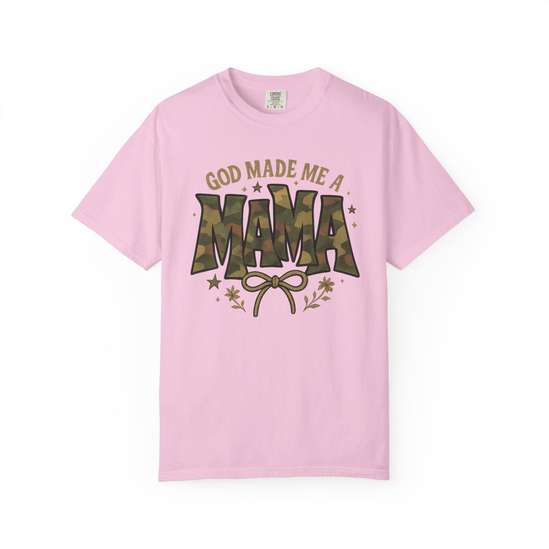 Light pink God Made Me a Mama tee, featuring camouflage MAMA graphic, bow illustration, floral and star accents, designed for comfort and style.