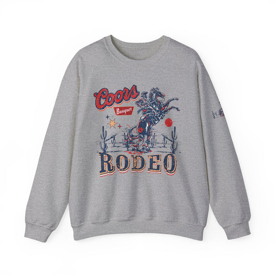 A grey Coors Rodeo Crew sweatshirt with a graphic design, ideal for any situation. Unisex heavy blend crewneck made of 50% cotton and 50% polyester, featuring ribbed knit collar and no itchy side seams.