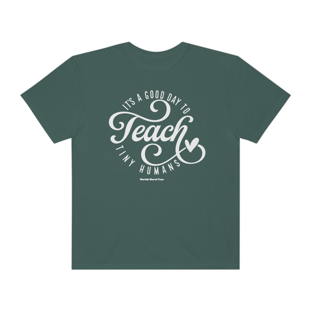 Unisex Teach Tiny Humans Tee, a green t-shirt with white text. Made of 80% ring-spun cotton and 20% polyester, featuring a relaxed fit and rolled-forward shoulder. From Worlds Worst Tees.
