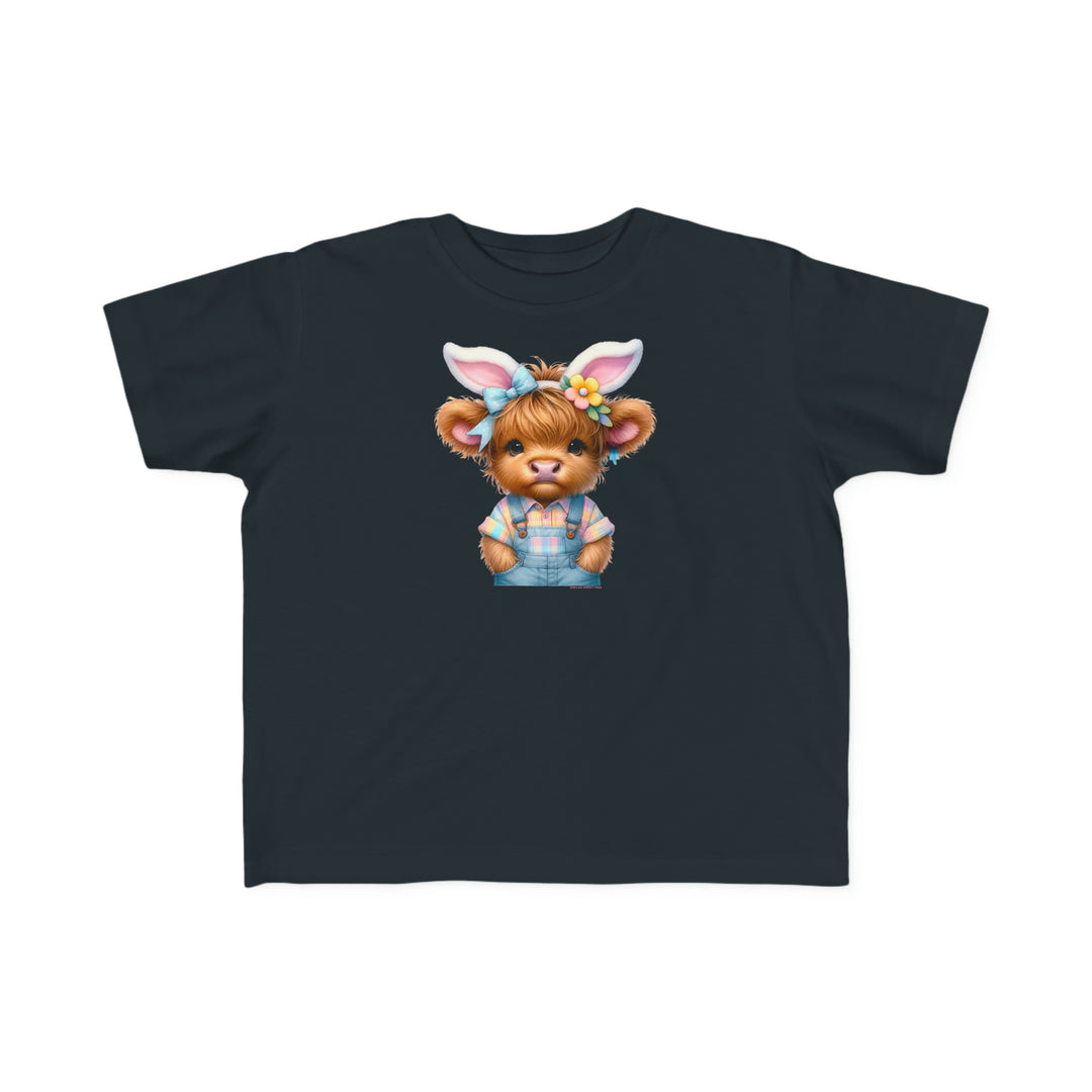 Easter Cow Toddler Tee: A black t-shirt featuring a cartoon cow in bunny ears, perfect for sensitive skin. Made of 100% combed ringspun cotton, light fabric, classic fit, tear-away label, and true-to-size.