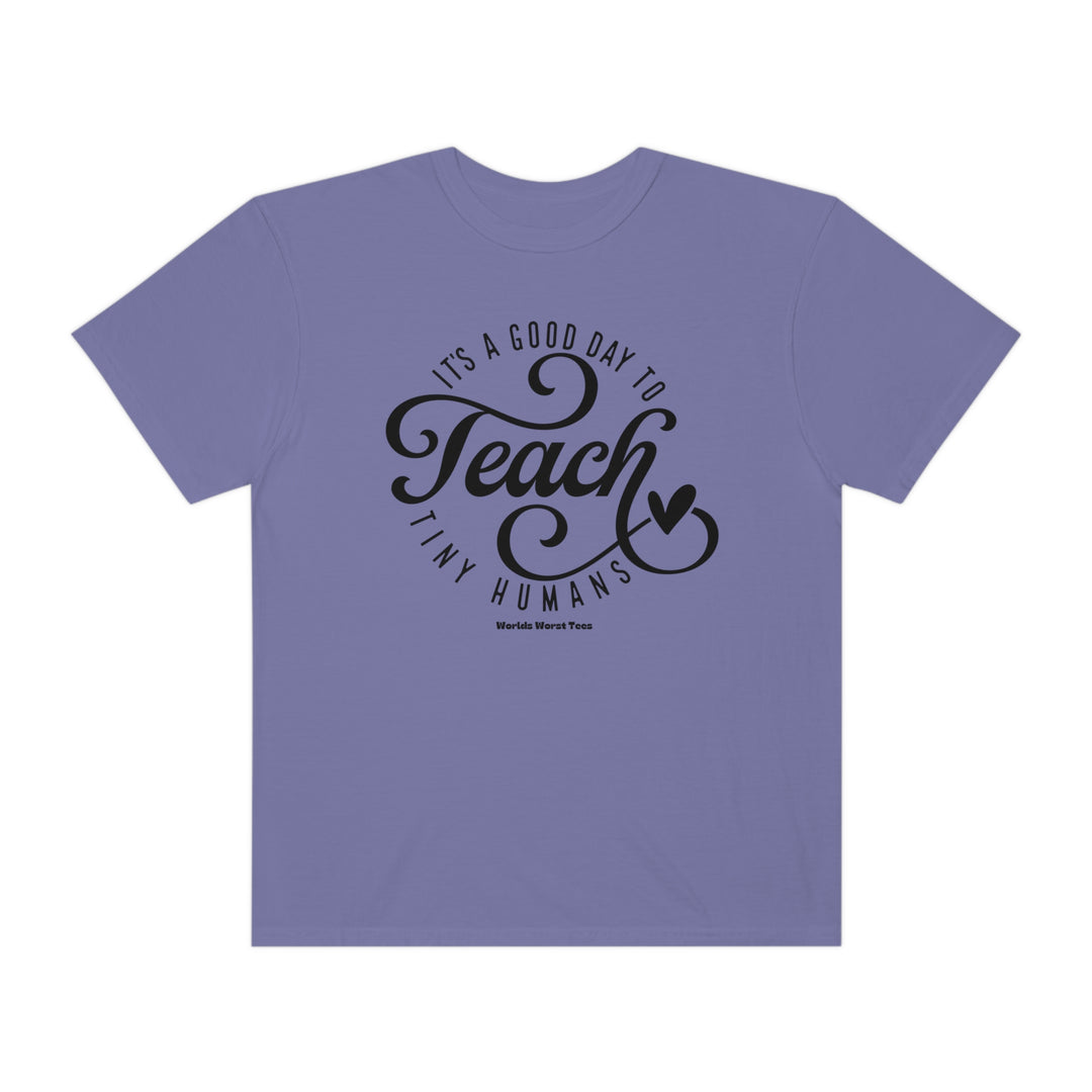 Unisex Teach Tiny Humans Tee: Purple t-shirt with black text. Luxurious 80% ring-spun cotton, 20% polyester fabric. Relaxed fit, rolled-forward shoulder, back neck patch. Ideal for comfort and style.