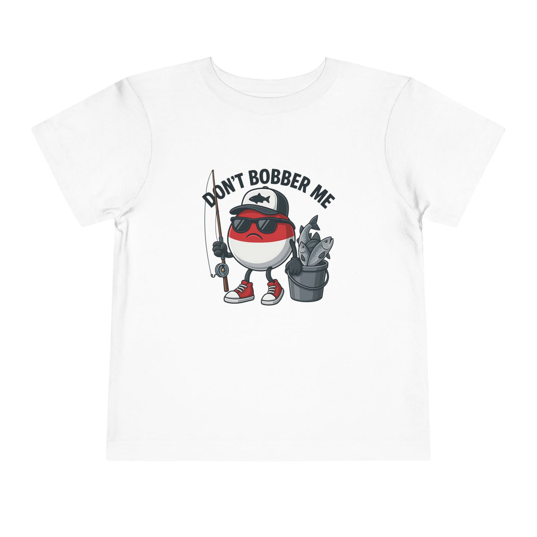 Don't Bobber Me Toddler Tee: Cartoon bobber character with sunglasses and cap, holding a fishing rod and fish bucket, printed on a white Bella Canvas toddler T-shirt.