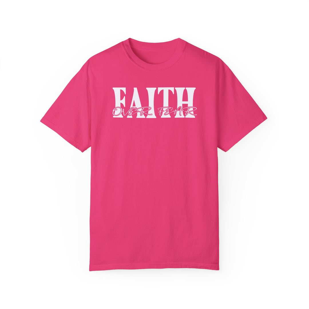 A Faith Over Fear Tee, a pink shirt with white text, crafted from 100% ring-spun cotton. Garment-dyed for coziness, featuring a relaxed fit and durable double-needle stitching. Ideal for daily wear.