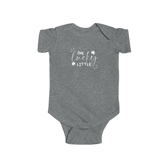 A grey baby bodysuit with white text, featuring the title One Lucky Little Onesie from Worlds Worst Tees. Made of 100% cotton, light fabric, with ribbed knit bindings and plastic snaps for easy changing access.