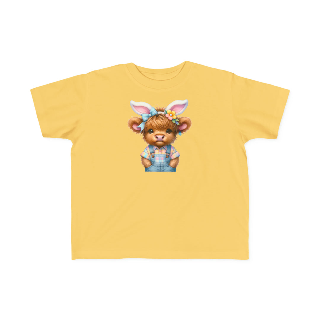 Easter Cow Toddler Tee featuring a cartoon cow in blue overalls and bunny ears on a yellow shirt. Soft, 100% combed ringspun cotton, light fabric, classic fit, perfect for sensitive skin.