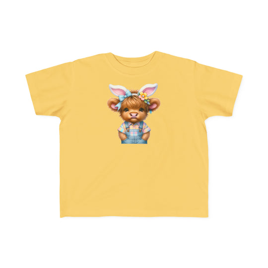 Easter Cow Toddler Tee featuring a cartoon cow in blue overalls and bunny ears on a yellow shirt. Soft, 100% combed ringspun cotton, light fabric, classic fit, perfect for sensitive skin.