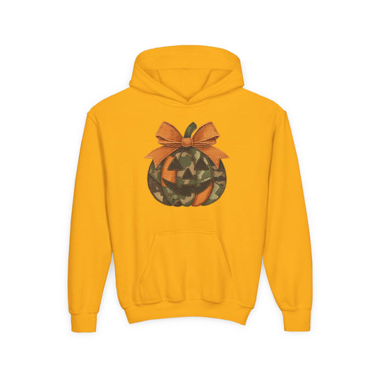 Jackie O Youth Hoodie features a mustard-yellow design with a jack-o’-lantern graphic in camouflage and orange, topped with a bow.