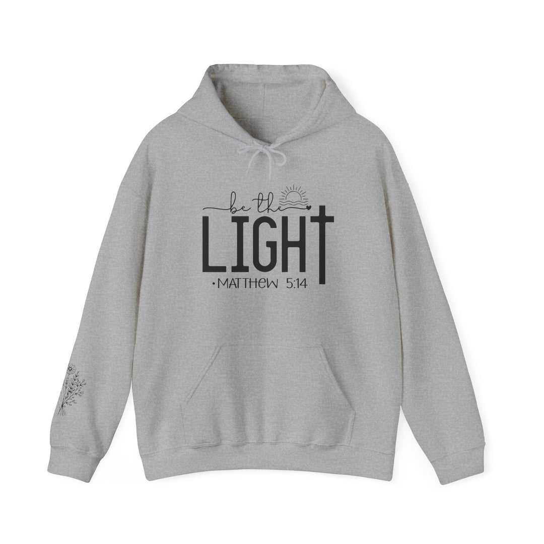 A cozy unisex Be the Light Hoodie in grey, featuring black text. Made of 50% cotton, 50% polyester blend for warmth and comfort. Includes kangaroo pocket and matching drawstring hood.