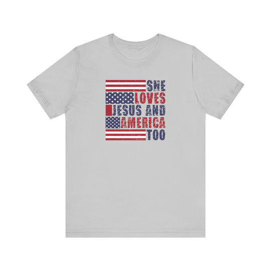 A classic She Loves Jesus and America Tee, a unisex jersey shirt with red and blue text. Made of 100% cotton, ribbed knit collars, and tear-away label. Sizes XS to 3XL.