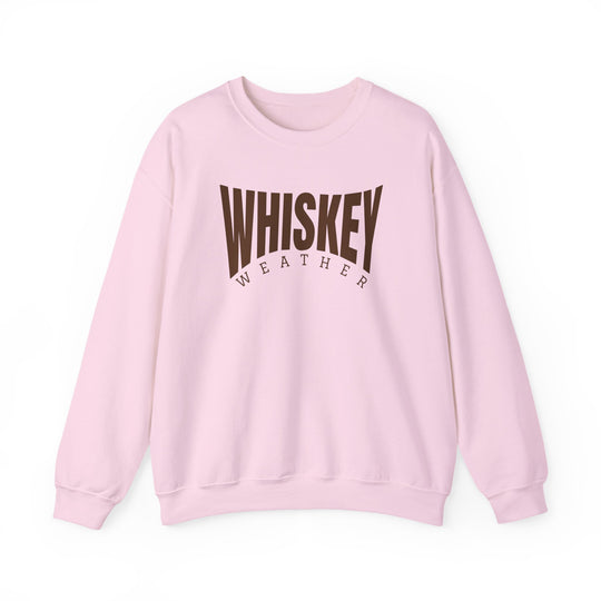 Light pink crewneck sweatshirt with WHISKEY in bold brown and WEATHER smaller beneath. Comfortable, unisex fit with durable stitching and sustainable materials.