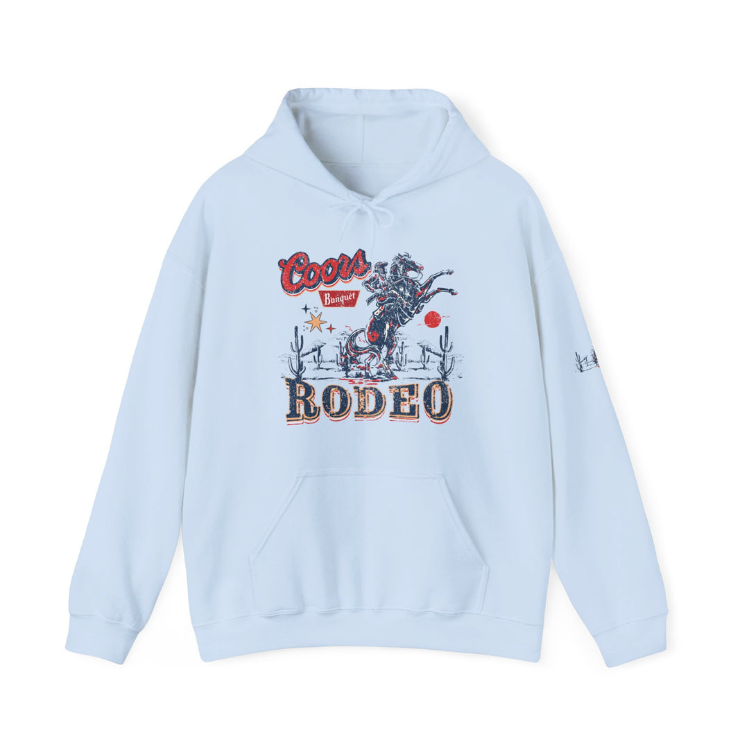 A Coors Rodeo Hoodie, a light blue sweatshirt with a graphic design. Unisex heavy blend, 50% cotton, 50% polyester, kangaroo pocket, drawstring hood. Ideal for warmth and comfort.