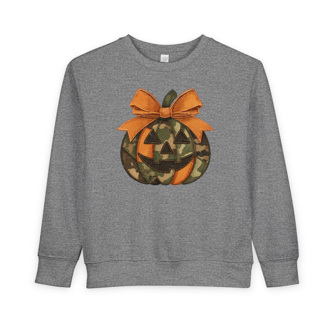 Heather-gray Jackie O Toddler Crew sweatshirt with a stylized jack-o’-lantern graphic, featuring orange-camouflage panels and a stitched-look bow, designed for toddlers.