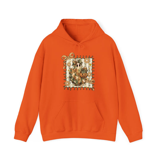 Orange Quilted Ghost Hoodie featuring a ghost in camo with a bow and jack-o’-lantern, framed by ribbon swirls and daisies. Cozy blend with a kangaroo pocket.