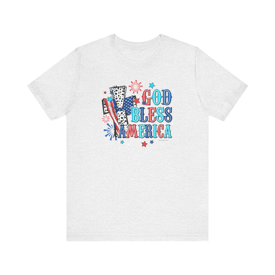 A white t-shirt featuring a cross and fireworks design, embodying the title God Bless America Cross Tee from Worlds Worst Tees. Unisex jersey tee with ribbed knit collars, taping on shoulders, and 100% Airlume combed cotton.