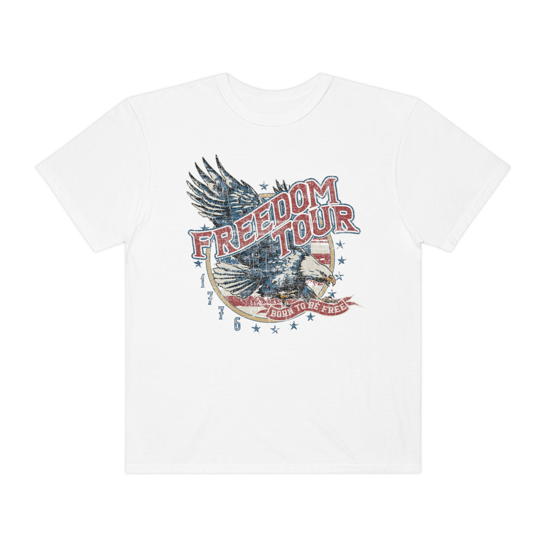 Alt text: Freedom Tour Tee: White t-shirt featuring a bold eagle graphic design. 100% ring-spun cotton, garment-dyed for coziness. Relaxed fit, durable double-needle stitching, no side-seams for tubular shape.