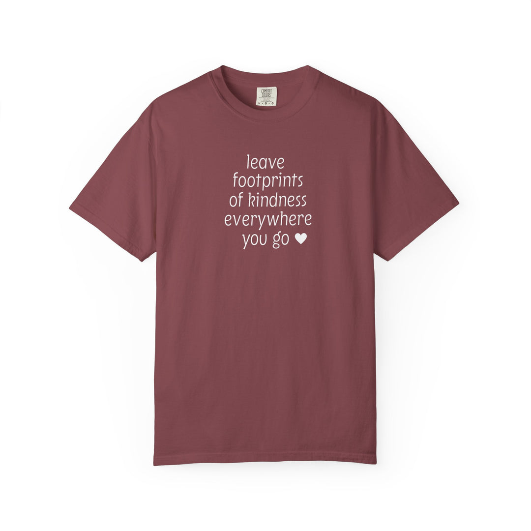Muted maroon Leave Kindness Tee with white text and heart on chest, short-sleeved, crewneck, laid flat. Features Comfort Colors brand tag.